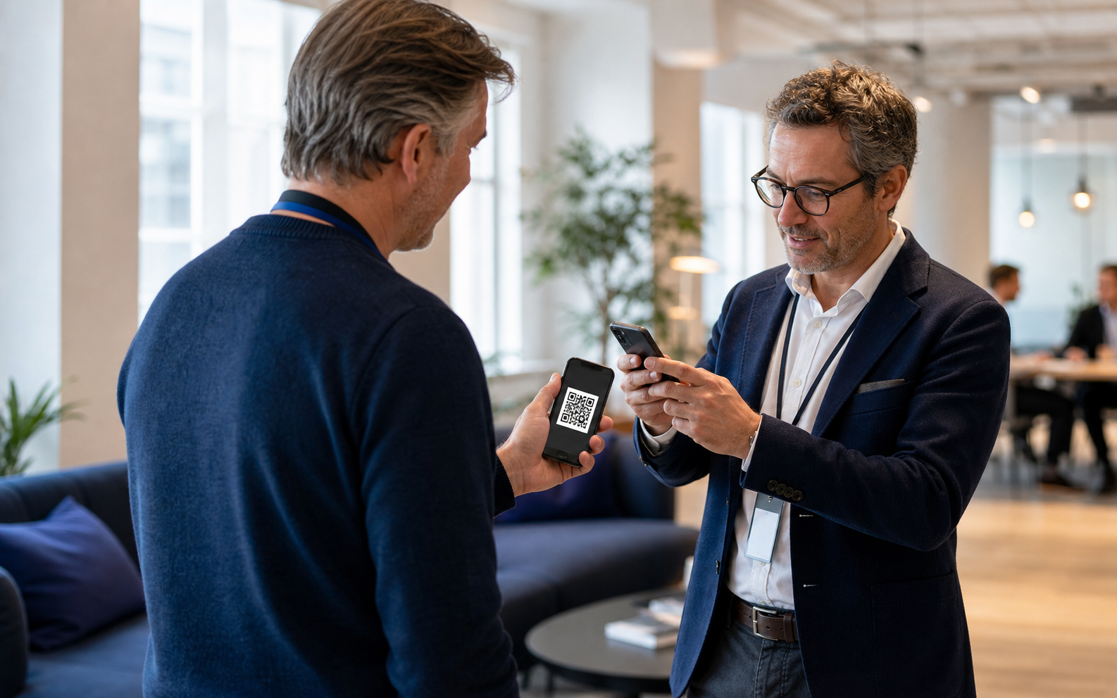 Two professionals exchanging a CardWithAI profile by QR code at a business meeting